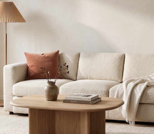 Living room with a cream sofa, oak coffee table and pleated floor lamp